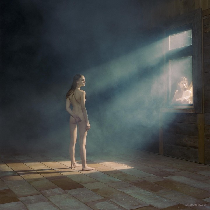 A nude woman stands in a hazy room with a second woman visible through a window.