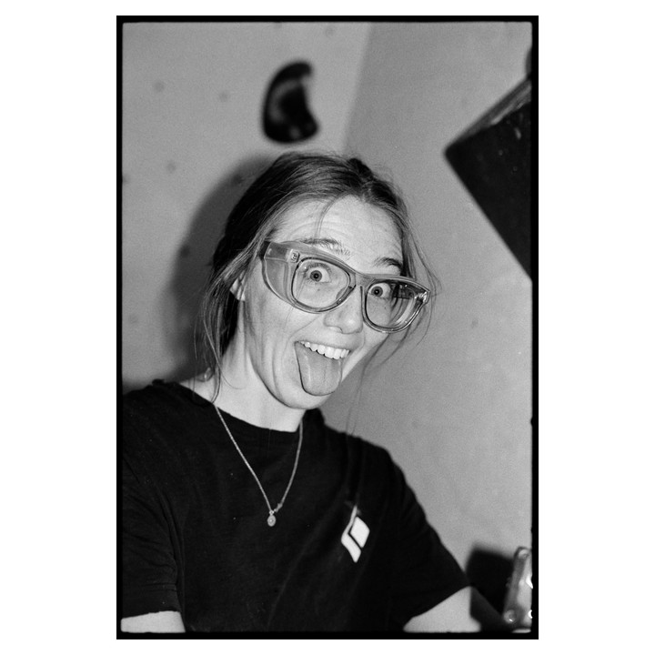A woman wearing safety glasses sticks out her tongue and makes a funny face.