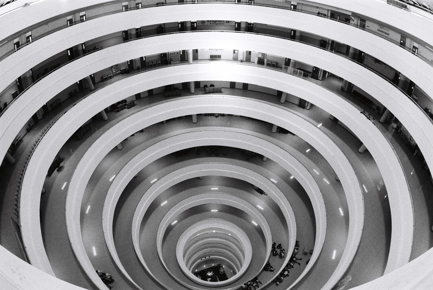 A high-angle view shows the interior of a building with circular balconies and a central open space.