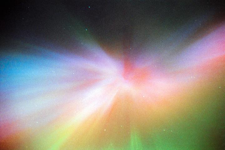 The aurora borealis glows in a vibrant display of color across the night sky.