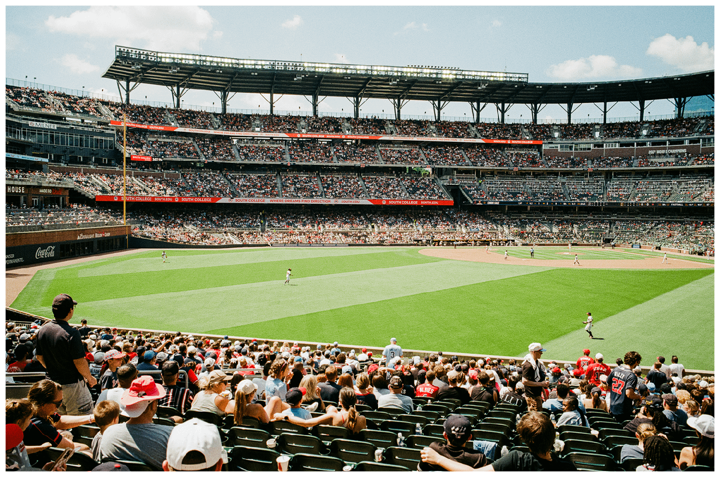 A baseball game is in progress at a stadium filled with spectators.