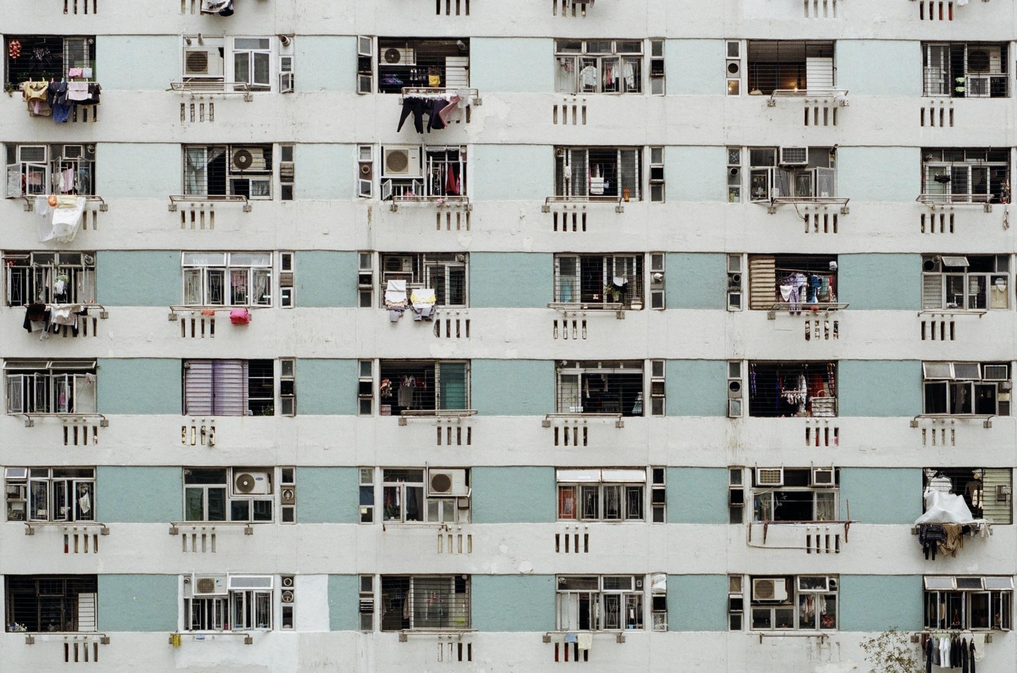 The facade of a public housing building in Hong Kong is covered with windows and clotheslines.