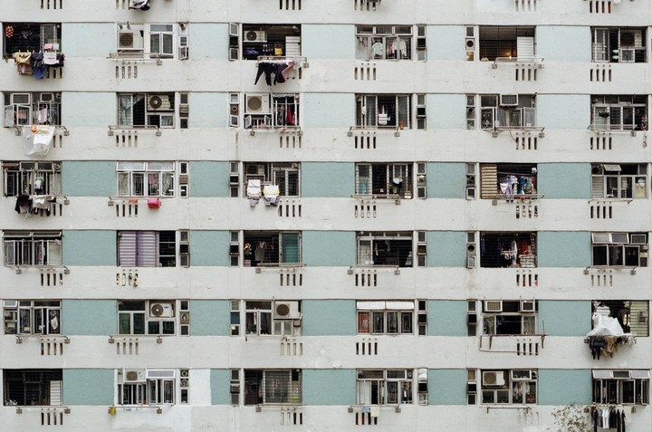 The facade of a public housing building in Hong Kong is covered with windows and clotheslines.