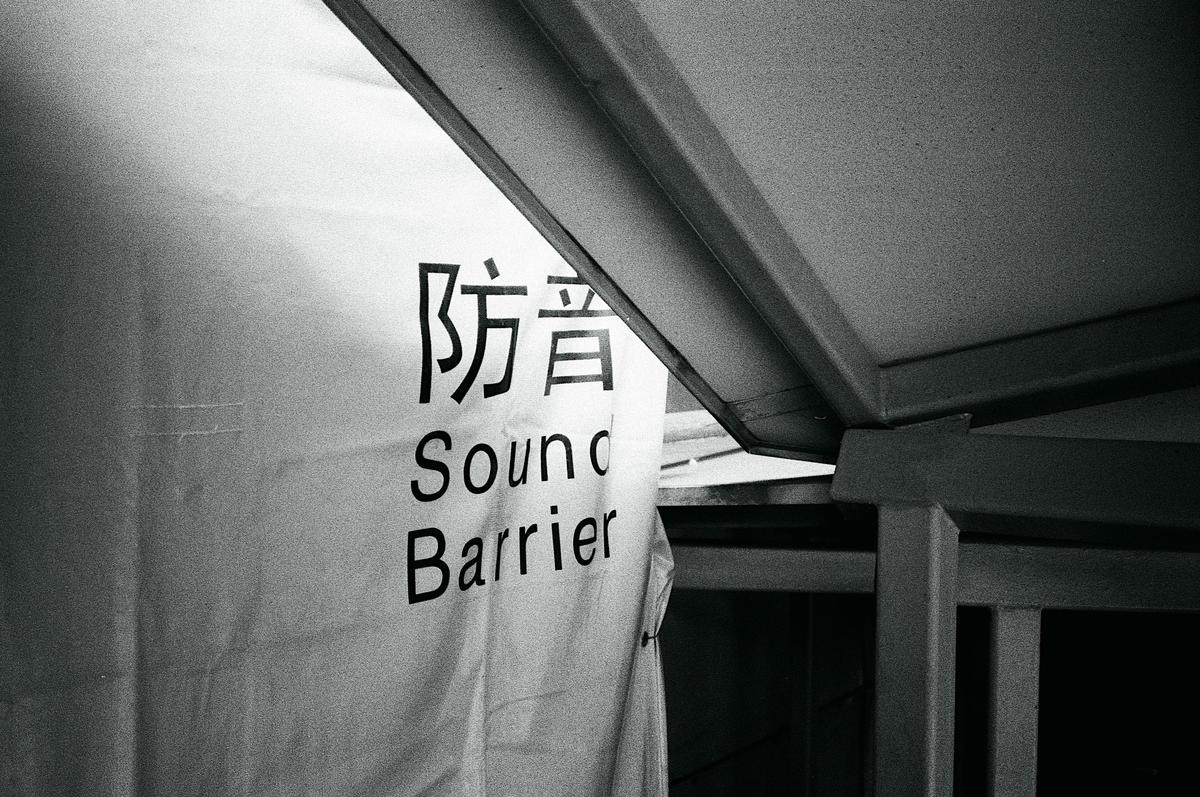 A white banner with "Sound Barrier" written in English and Japanese hangs next to a metal structure.