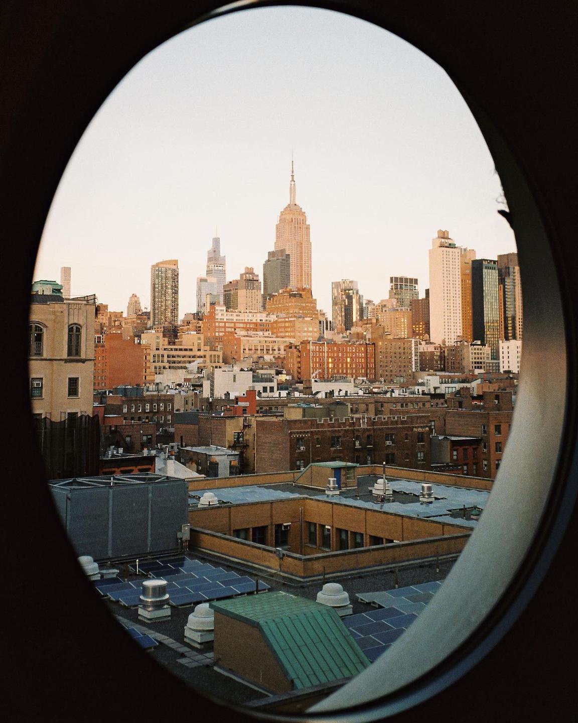 A cityscape with the Empire State Building is visible through an oval frame.