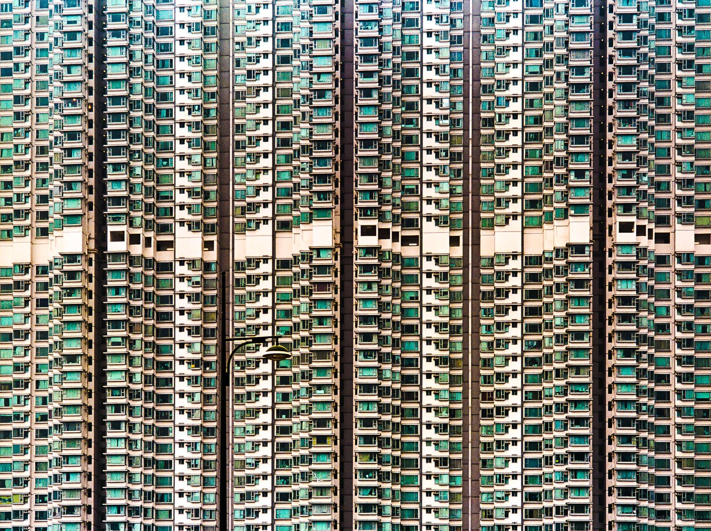 A tall building with many windows and balconies is visible from a distance.