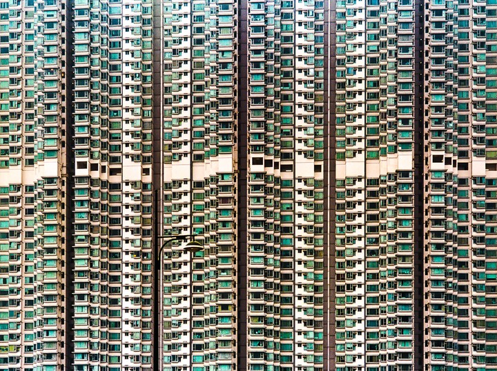 A tall building with many windows and balconies is visible from a distance.