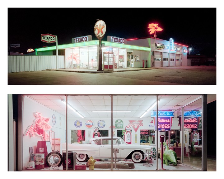 A vintage Texaco gas station with neon signs is illuminated at night, with a classic white car visible through the window of the service bay.