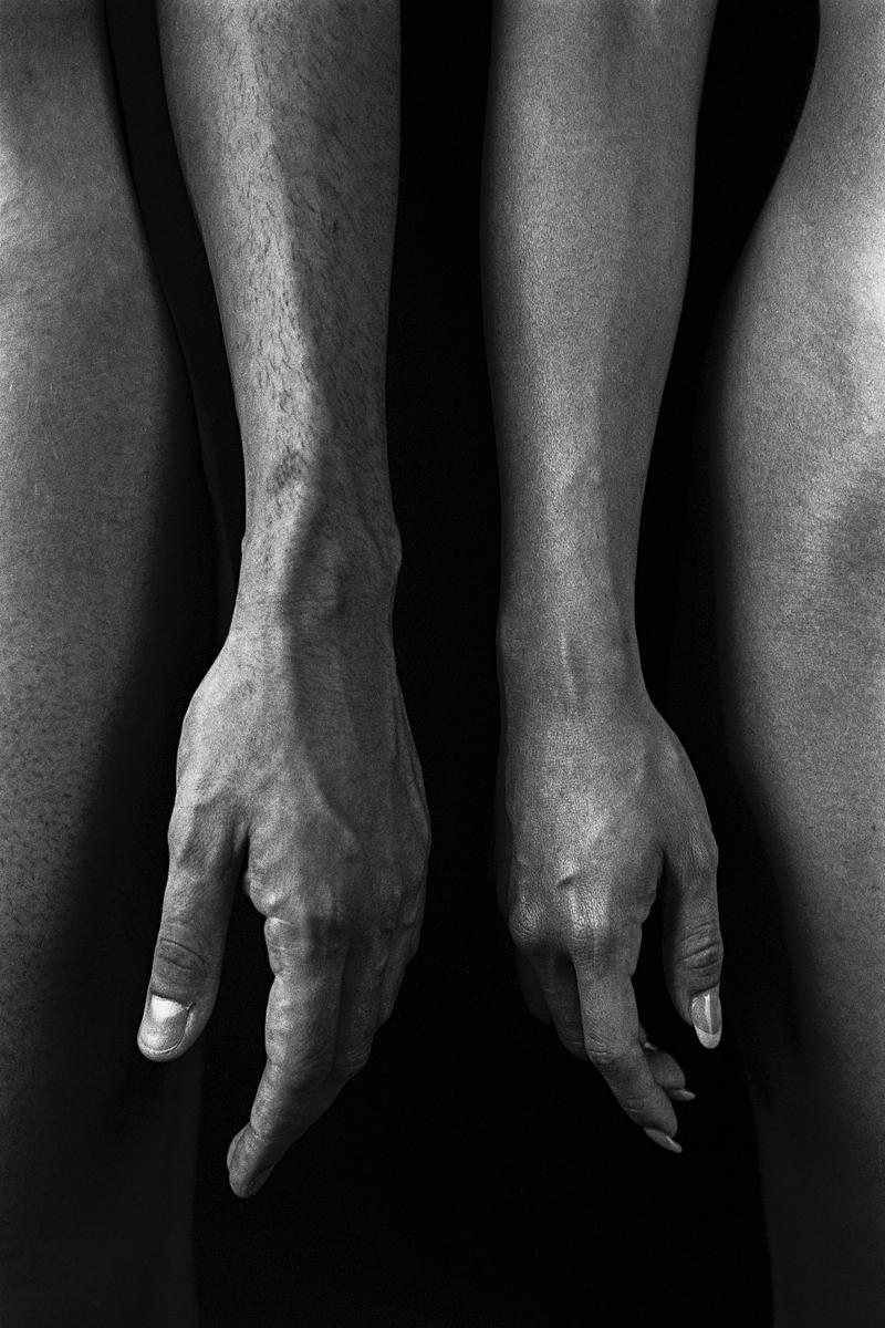 Two arms with hands hanging down are visible between two legs.