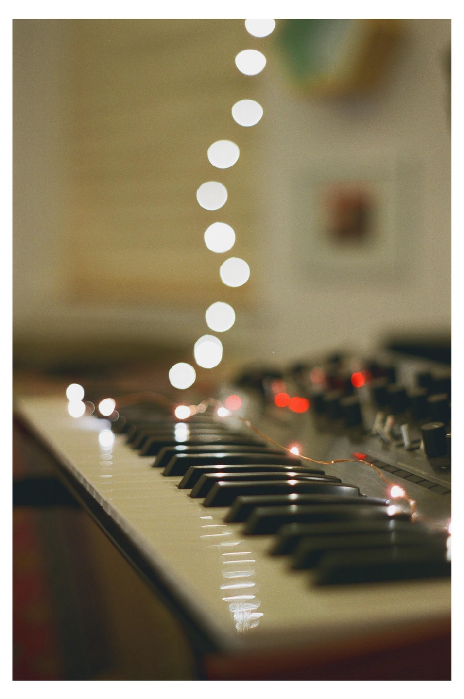 A string of lights illuminates the keys of a synthesizer.