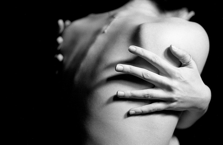 A woman's back and arm are visible in a black and white self-portrait.