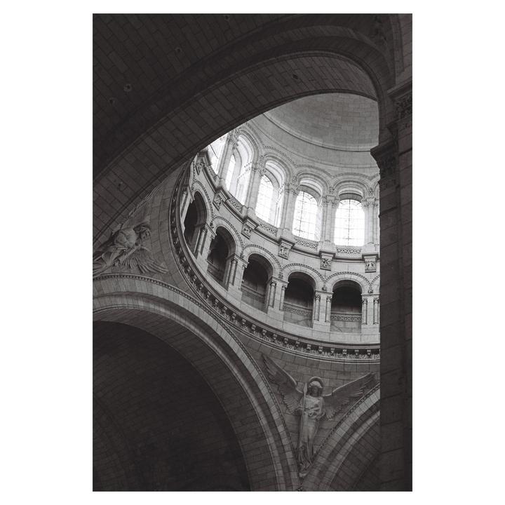 A low-angle view shows the interior of a large stone dome with arched windows and sculptures.