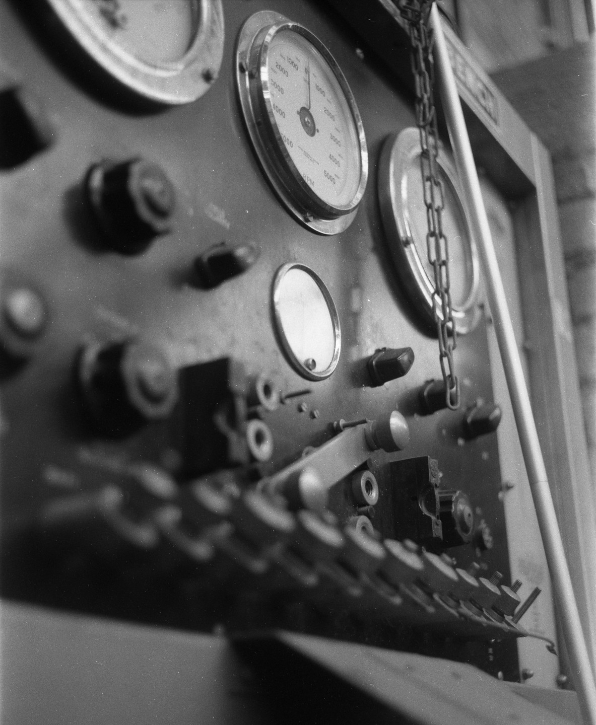 A close-up, low-angle view shows a control panel with gauges, knobs, and levers.