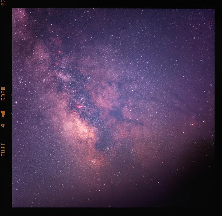 The Milky Way is visible in the night sky, with a dark area at the bottom right.