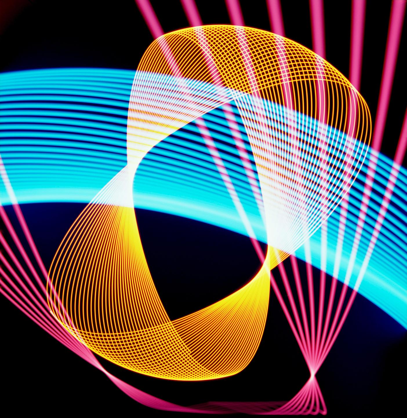 Multiple overlapping light patterns in blue, pink, and yellow are visible against a dark background.