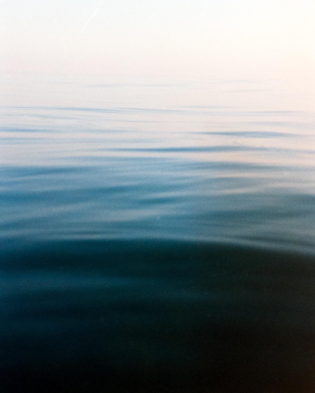The surface of the sea shows gentle ripples under a bright sky.