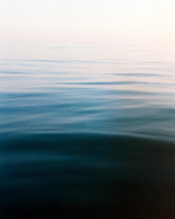 The surface of the sea shows gentle ripples under a bright sky.