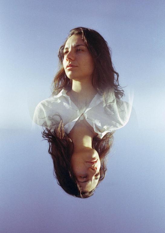 A woman's face is shown twice, once upright and once inverted, against a blue background.
