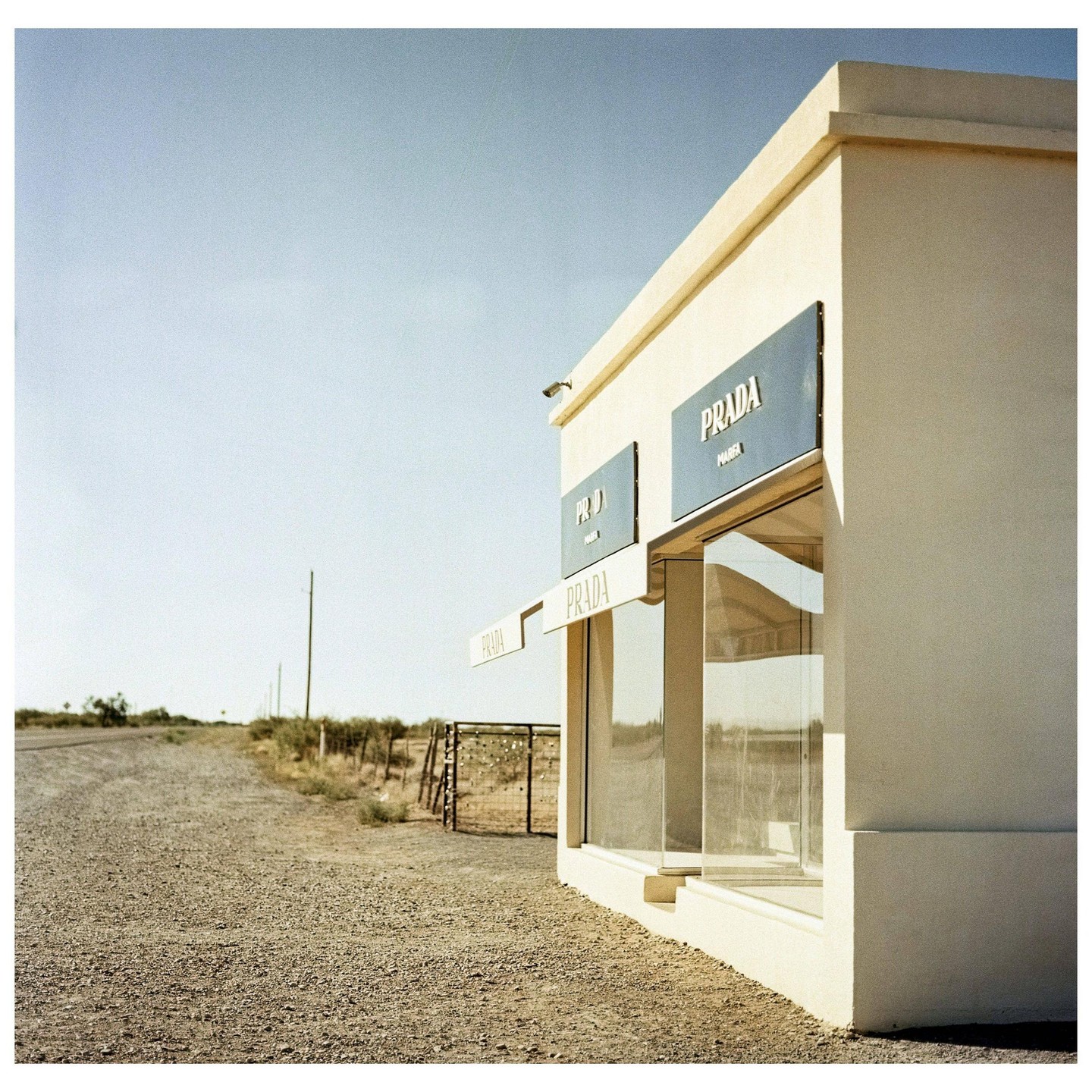 A Prada store stands alone on a gravel road in the desert.