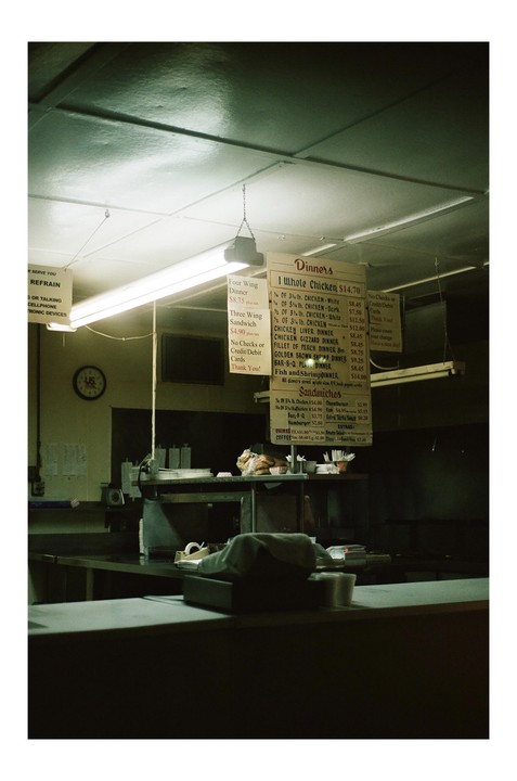A menu hangs above a counter in a closed restaurant.