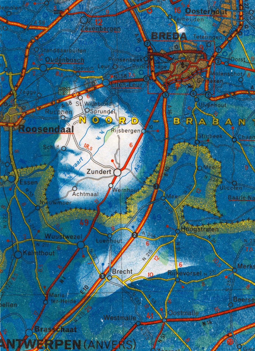 A cyanotype print of a face is visible on a vintage map of the Netherlands and Belgium.
