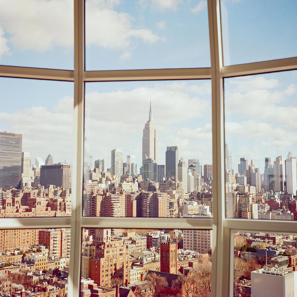 A cityscape with the Empire State Building visible through a window.