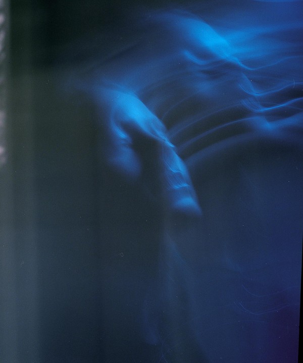 A blurry blue light streaks across a dark background.
