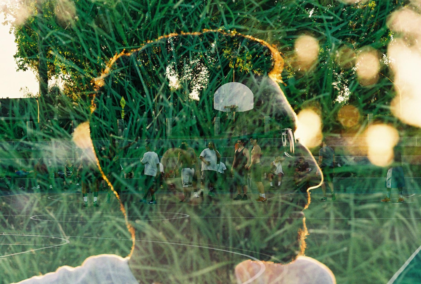 A double exposure shows a man's profile superimposed over a basketball court with several men and a basketball hoop.