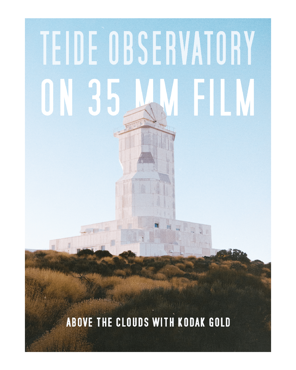 A white observatory building stands on a hill covered with dry grass under a clear sky.