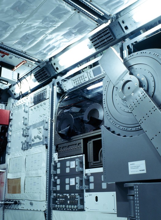 A complex array of scientific equipment and panels fills the interior of a spacecraft.
