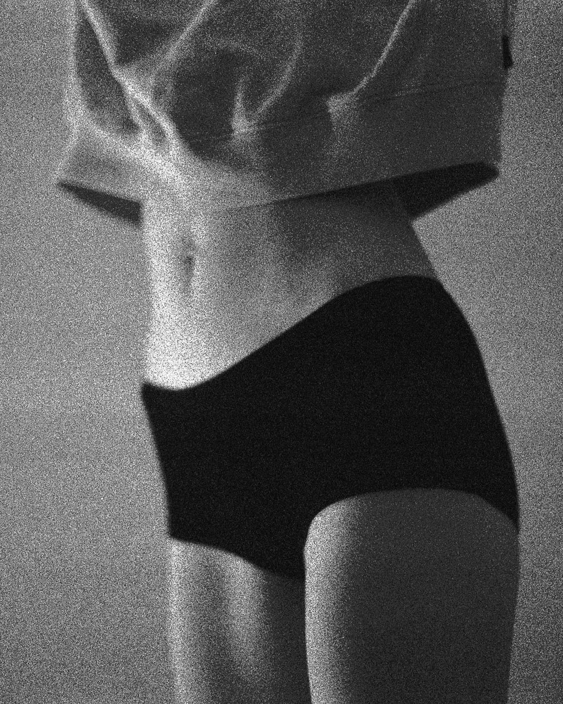 A woman's torso is visible, wearing a cropped top and underwear.