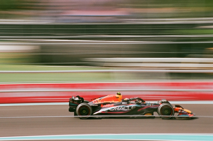 A race car speeds along a track with a blurred background.