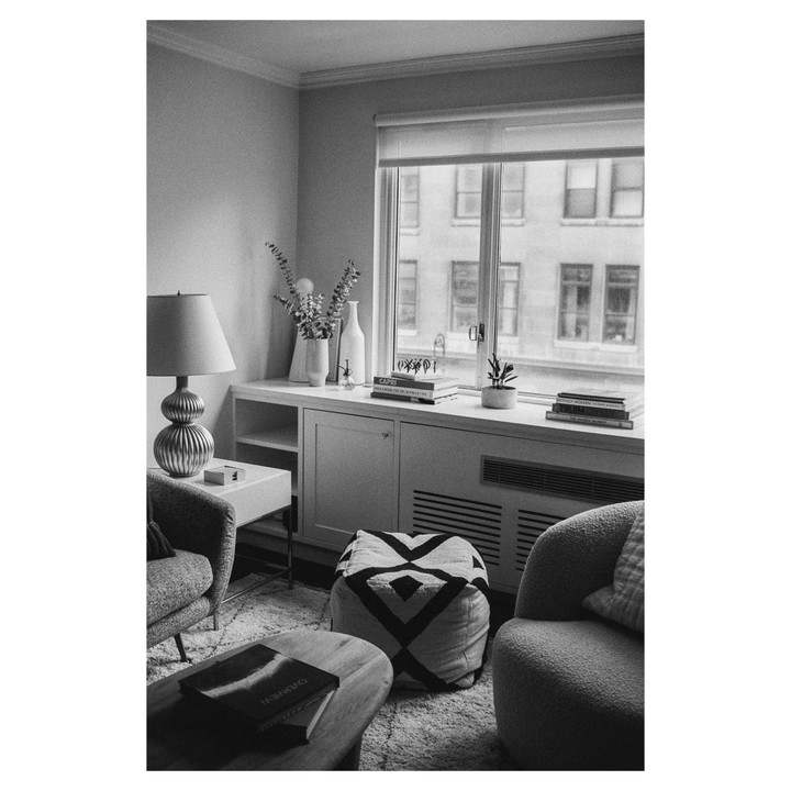 A cozy apartment living room is visible with a window looking out onto a building.
