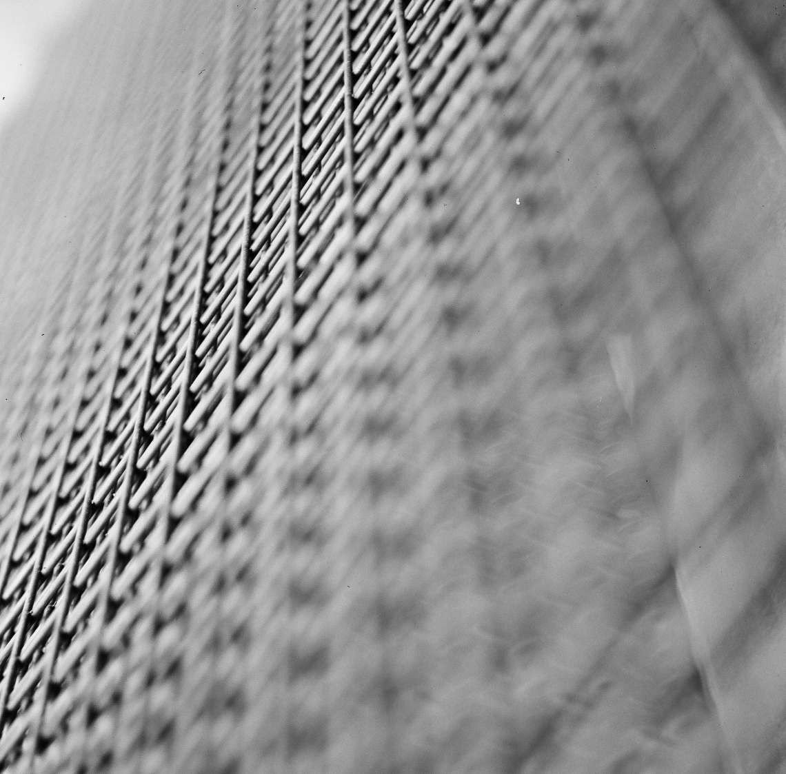 A close-up, low-angle view shows a metal grate with a blurred background.