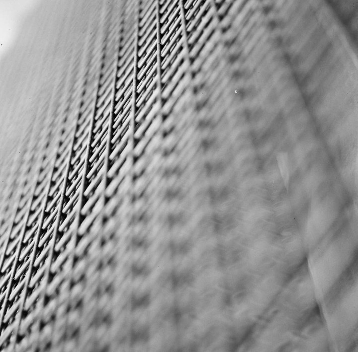 A close-up, low-angle view shows a metal grate with a blurred background.