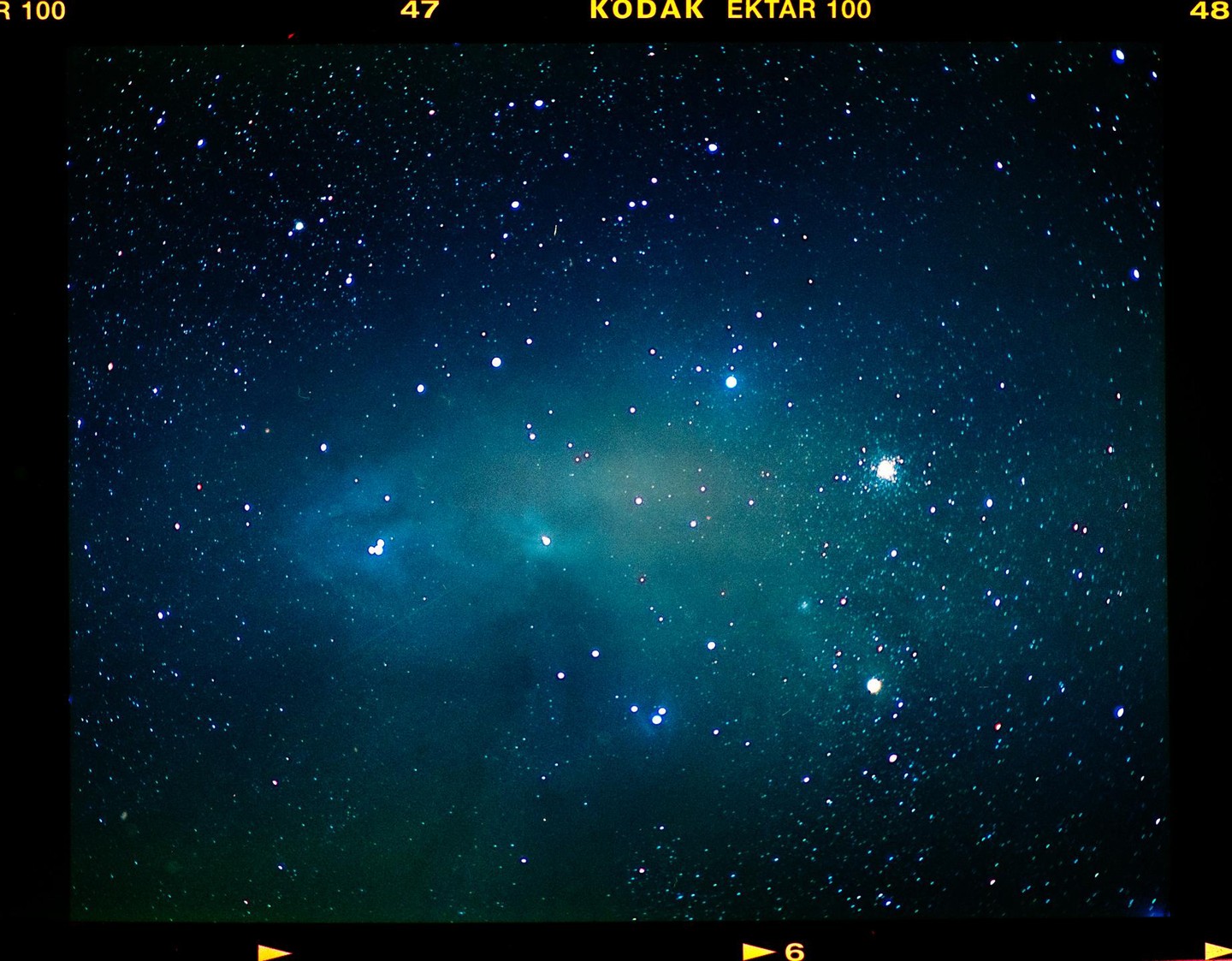 A cosmic space cloud is visible among many stars in the night sky.