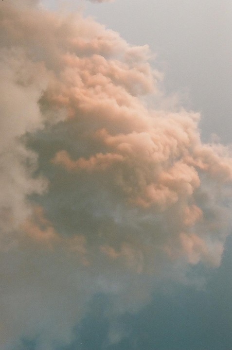 A large cloud formation fills the sky, with some clouds appearing pink and others blue.