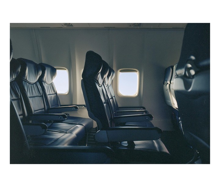 Empty passenger seats are visible inside an airplane cabin.