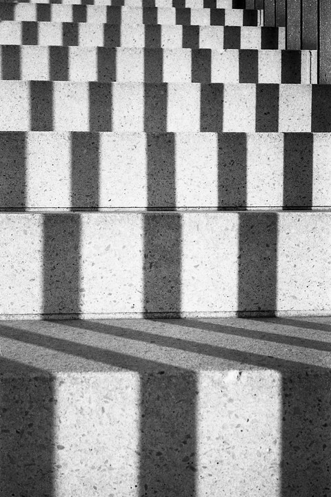 Sunlight casts strong shadows on a concrete staircase.