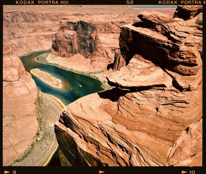 A river winds through a deep canyon with steep, rocky walls under a clear sky.
