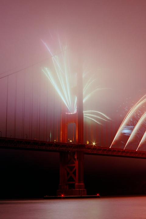 Fireworks explode over the Golden Gate Bridge at night.
