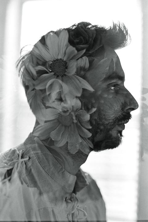 A man's profile is superimposed with flowers in a black and white double exposure.