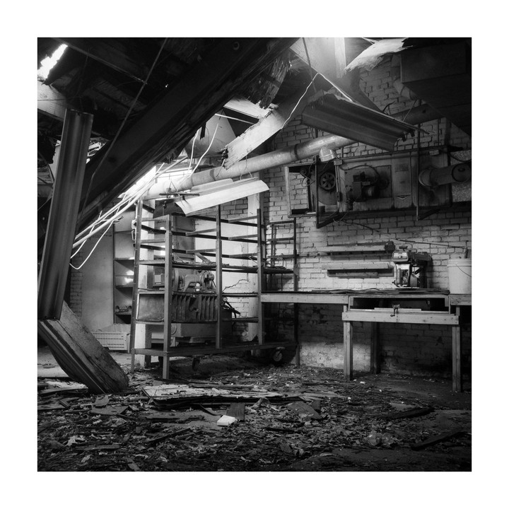 A dilapidated room with a collapsed ceiling, exposed brick walls, and debris scattered across the floor.