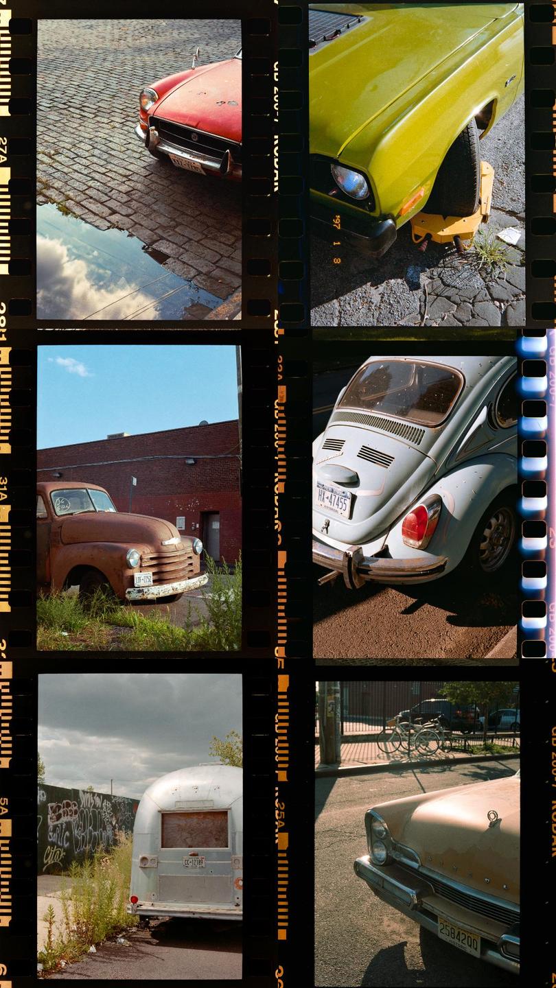 Six different photographs of vintage cars and a trailer are arranged in a grid, with film borders visible between them.