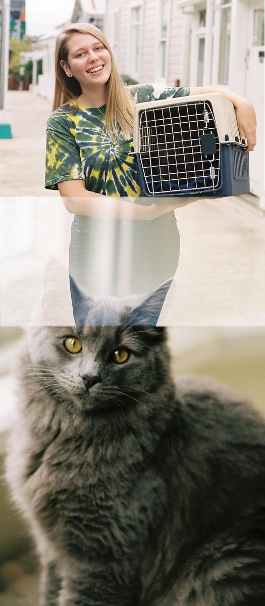 A woman holds a pet carrier while a cat with yellow eyes is visible below her.
