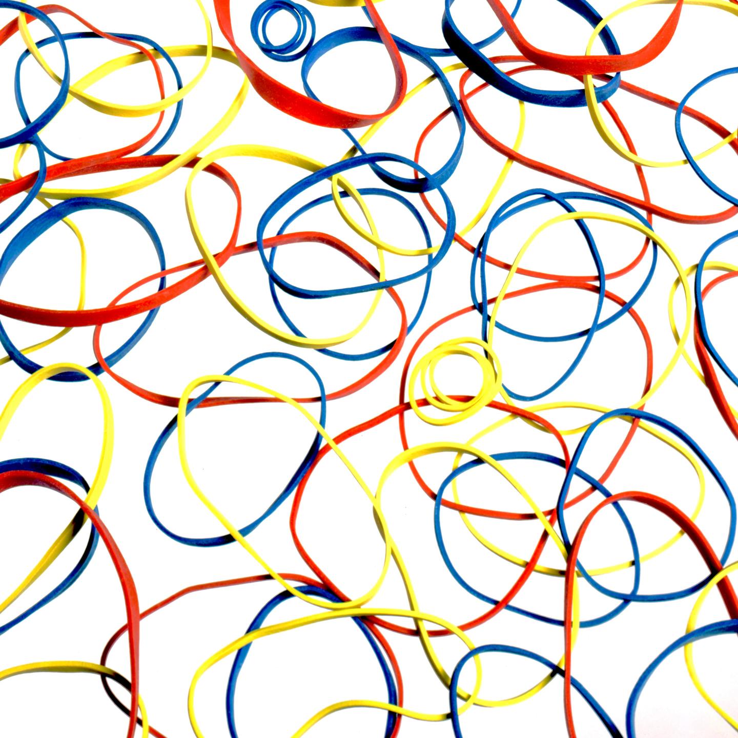 A white surface is covered with red, yellow, and blue rubber bands.