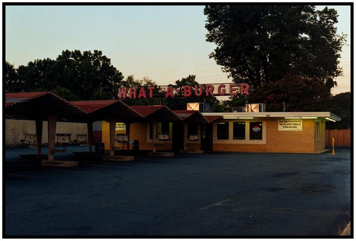 A "What-A-Burger" restaurant with car service bays is visible under a pale sky.