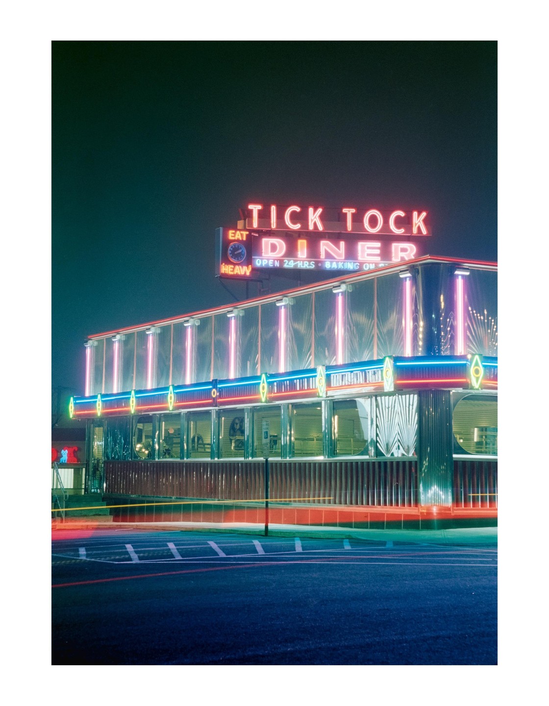 The Tick Tock Diner is illuminated by neon lights at night.