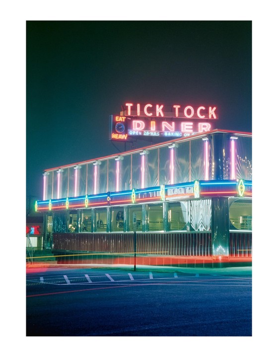 The Tick Tock Diner is illuminated by neon lights at night.