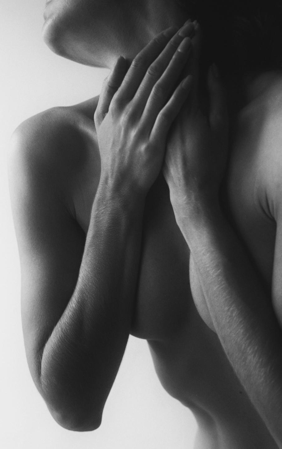 A woman's bare shoulders, neck, and arms are visible in a self-portrait.